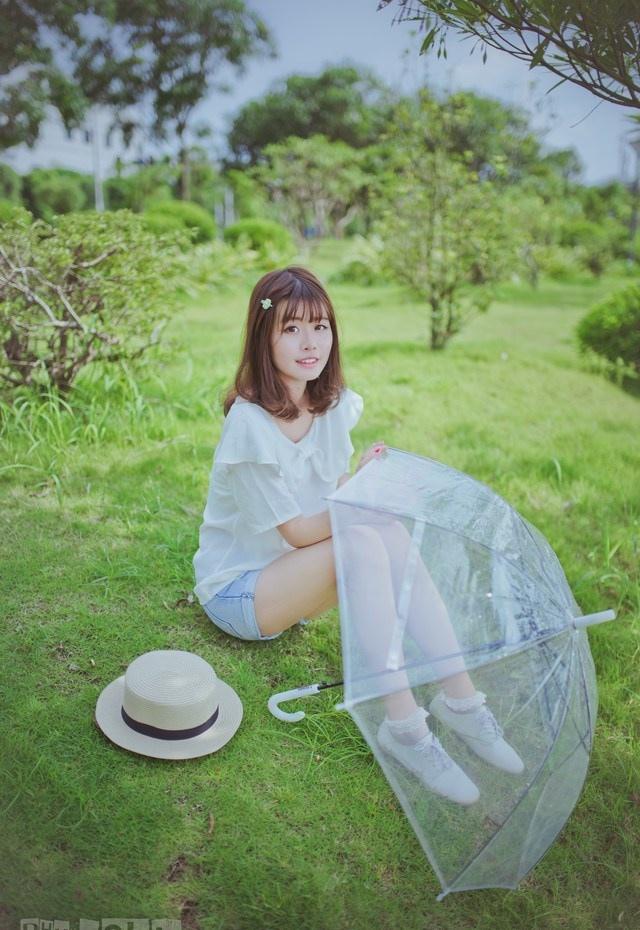 夏日頭戴小花的清新性感少女撐傘漫步
