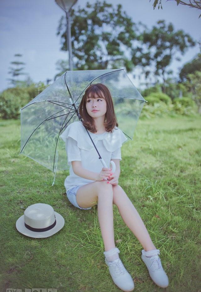 夏日頭戴小花的清新性感少女撐傘漫步