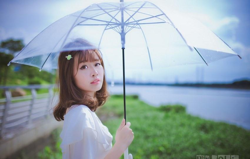 夏日頭戴小花的清新性感少女撐傘漫步