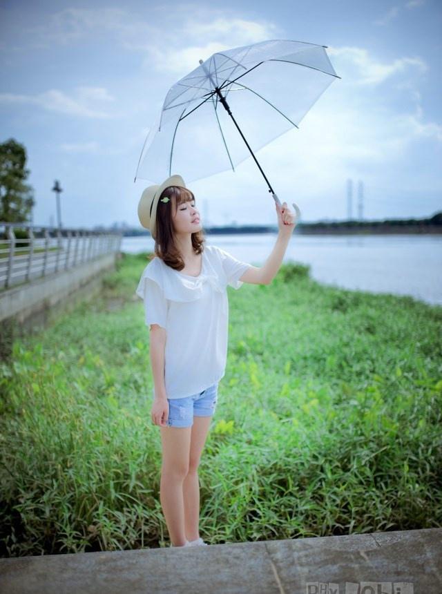 夏日頭戴小花的清新性感少女撐傘漫步