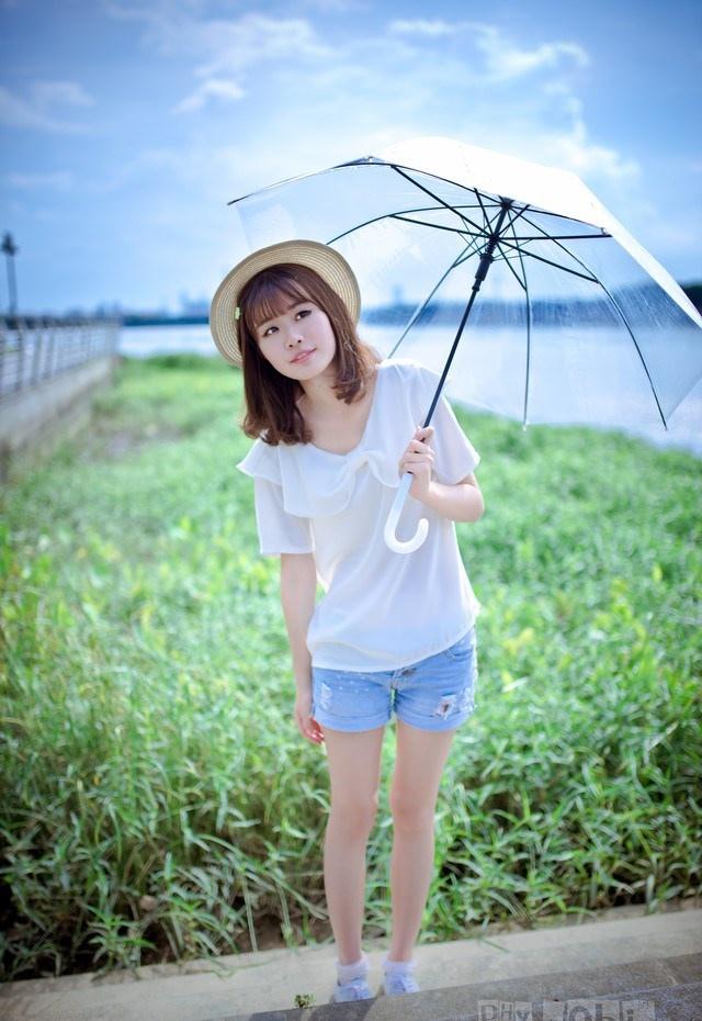 夏日頭戴小花的清新性感少女撐傘漫步