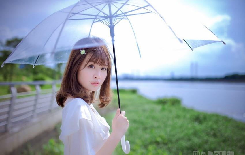 夏日頭戴小花的清新性感少女撐傘漫步