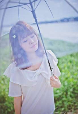 夏日頭戴小花的清新性感少女撐傘漫步