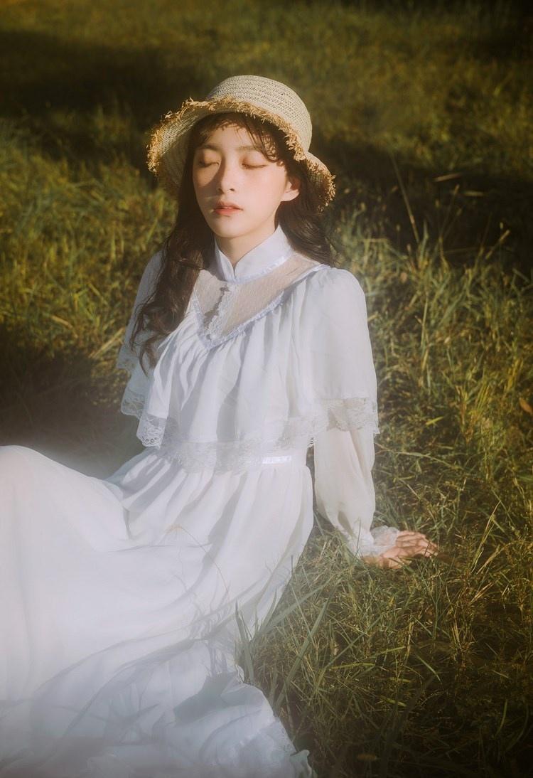 文藝美女潔白長裙濃密卷發手捧鮮花叢林寫真圖片