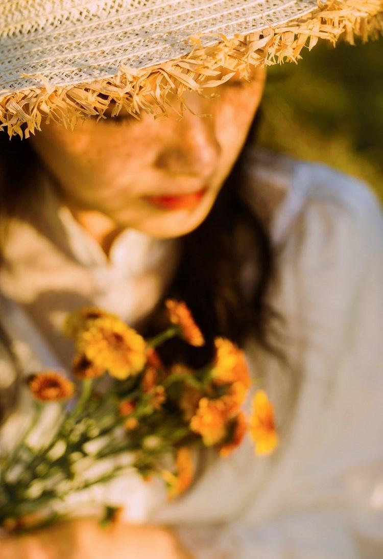 文藝美女潔白長裙濃密卷發手捧鮮花叢林寫真圖片