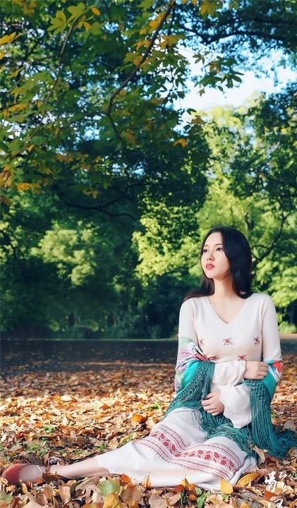 大樹下清純靈動美女手捧蘋果纖細身形圖片