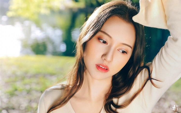 大樹下清純靈動美女手捧蘋果纖細身形圖片