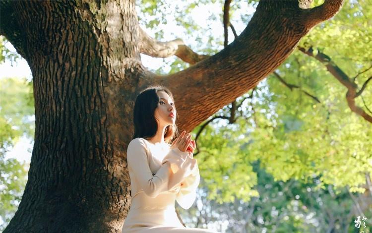 大樹下清純靈動美女手捧蘋果纖細身形圖片